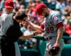 Los Angeles relief pitcher Luke Bard, right, is tended to by an unidentified trainer after being hit by a Cleveland Indians' Carlos Santana line drive during the fifth inning of a baseball game in Cleveland, Sunday, Aug. 4, 2019. (AP Photo/Phil Long)