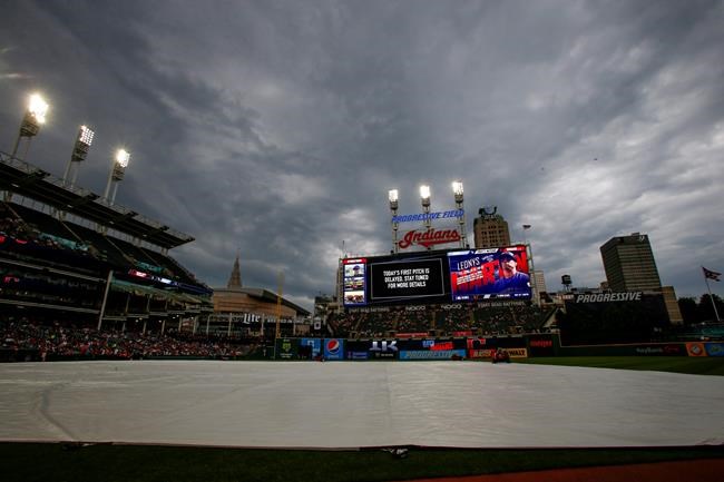 The tarp covers the infield as the the start of a baseball game between the Tampa Bay Rays at Cleveland Indians baseball game is being delayed, Saturday, May 25, 2019, in Cleveland. (AP Photo/Ron Schwane)