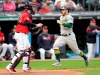 Oakland Athletics' Robbie Grossman, right, scores on Josh Phegley's single in the fourth inning of a baseball game against the Cleveland Indians, Monday, May 20, 2019, in Cleveland. Indians catcher Roberto Perez, left, looks on. (AP Photo/Tony Dejak)