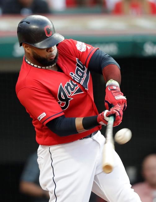 Cleveland Indians' Carlos Santana hits a sacrifice fly during the second inning of the team's baseball game against the Los Angeles Angels, Friday, Aug. 2, 2019, in Cleveland. Francisco Lindor scored on the play. (AP Photo/Tony Dejak)