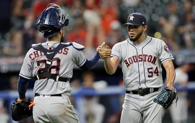 Houston Astros relief pitcher Roberto Osuna, right, is congratulated by catcher Robinson Chirinos after the Astros defeated the Cleveland Indians 2-0 in a baseball game, Tuesday, July 30, 2019, in Cleveland. (AP Photo/Tony Dejak)