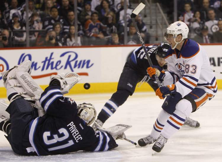 Trevor Hagan / The Canadian Press
Winnipeg Jets' goaltender Ondrej Pavelec (31) makes a sprawling save on Edmonton Oiler's Ales Hemsky (83) with Jets' Blake Wheeler (26) also in front of the net during first-period NHL hockey action in Winnipeg, Monday.