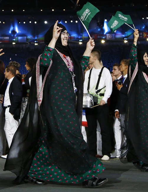 FILE - In this , Friday, July 27, 2012 file photo, Saudi Arabia's Wojdan Ali Seraj Abdulrahim Shahrkhani, parades, along with her team, during the Opening Ceremony at the 2012 Summer Olympics in London. Talks have been underway to allow Shahrkhani, a judo athlete, to compete for Saudi Arabia at the Olympics after the sport's governing federation said she would not be allowed to wear a headscarf. Saudi Arabia, which sent its first two female Olympians to the London Games, had only agreed to let women participate if they adhered to the kingdom's conservative Islamic traditions, including wearing a headscarf. But last Thursday, the International Judo Federation said Shahrkhani, would not be allowed to wear a headscarf because it was against principles of judo and raised safety concerns. (AP Photo/Matt Dunham)
