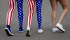 In this Thursday, Aug. 2, 2012 photo, Nick Miller, left, and his sister Kendall Miller, center, from San Francisco, wear leotards in the colors of the United States national flag as they walk with a friend through Olympic Park at the 2012 Summer Olympics, in London. Patriotism and the games have always gone together, but gone are the days when one just waved a flag. Now flags are worn, seen all over London and especially at Olympic Park and other spots where the games are being played. (AP Photo/Ben Curtis)