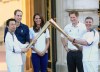 Prince William and his wife Kate, the Duke and Duchess of Cambridge, and Prince Harry are joined by children from the Team Britain Ambition Program as they watch Wai Ming hand over the London 2012 Olympic Torch to John Hulse during a visit to Buckingham Palace in London, on Day 69 of the London 2012 Olympic Torch Relay on Thursday, July 26, 2012. (AP Photo/Ian West, PA) UNITED KINGDOM OUT; NO SALES; NO ARCHIVE