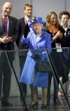 Britain's Queen Elizabeth II waves to spectators inside the Aquatics center, in the Olympic Park at the 2012 Summer Olympics, Saturday, July 28, 2012, in London. (AP Photo/Ben Curtis)