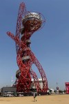A man walks near the Orbit tower at the Orbit Olympic Circus three days ahead of the 2012 Summer Olympics, Tuesday, July 24, 2012, in London. (AP Photo/Daniel Ochoa De Olza)