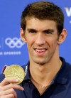 United States swimmer Michael Phelps holds up one of his gold medals during a news conference at the 2012 Summer Olympics, London, Sunday, Aug. 5, 2012. (AP Photo/Kirsty Wigglesworth)