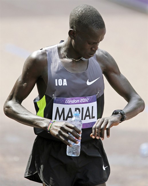 Gour Marial, who is stateless, checks his time after finishing the men's marathon at the 2012 Summer Olympics, Sunday, Aug. 12, 2012, in London. Marial, from South Sudan, competed in the marathon under the Olympic flag. (AP Photo/Mike Groll)