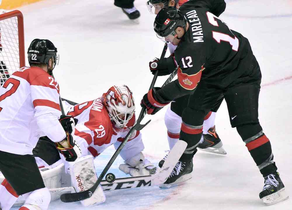 NATHAN DENETTE / THE CANADIAN PRESS
Canada forward Patrick Marleau (12) tries to score on Austria goaltender Bernhard Starkbaum (29) as defenceman Thomas Pock (22) looks on during second period round robin men's hockey action at the Sochi Winter Olympics on Friday, in Sochi, Russia.