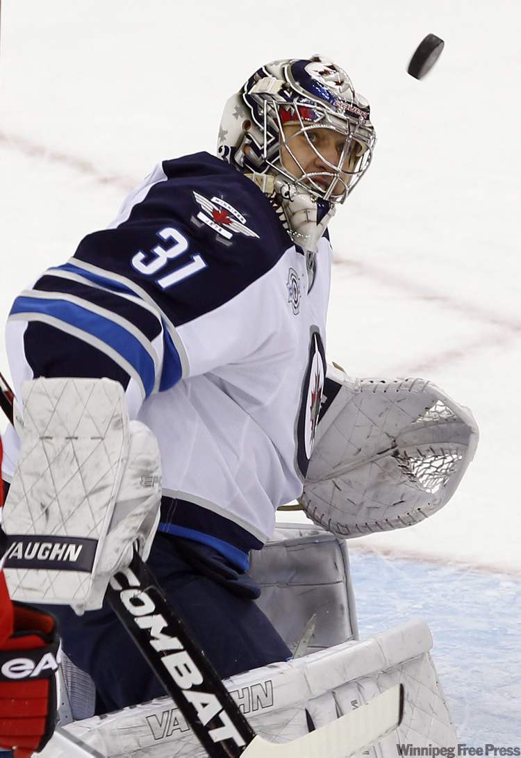 Rich Schultz / The Associated Press
Winnipeg Jets goalie Ondrej Pavelec keeps his eye on the puck as he makes a save against the New Jersey Devils during the second period of their NHL game in Newark, N.J., Tuesday.