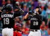 Colorado Rockies' Charlie Blackmon, left, waits to congratulate Nolan Arenado on the latter's two-run home run off St. Louis Cardinals starting pitcher Michael Wacha during the first inning of a baseball game Tuesday, Sept. 10, 2019, in Denver. (AP Photo/David Zalubowski)