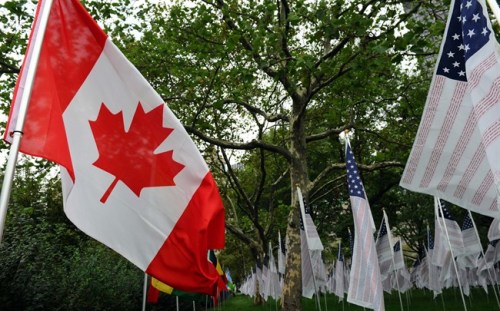 A Canada flag blows in the wind alongside American flags signed with the names of 9-11 victims at Battery Park blocks from ground zero on the tenth anniversary of the terrorist attacks in New York on Sunday, September 11, 2011. THE CANADIAN PRESS/Sean Kilpatrick