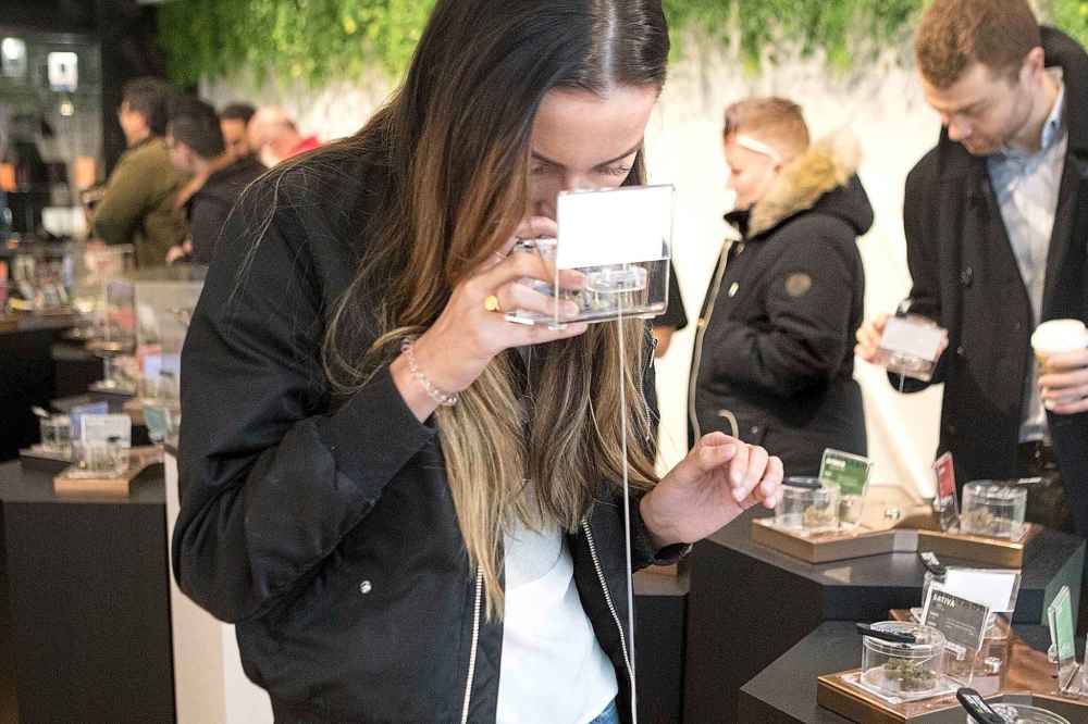 A customer smells a sample as she shops for cannabis Monday on the first morning of opening for Toronto's Hunny Pot, one of the retail stores licensed to sell cannabis in Ontario. (Chris Young / The Canadian Press)