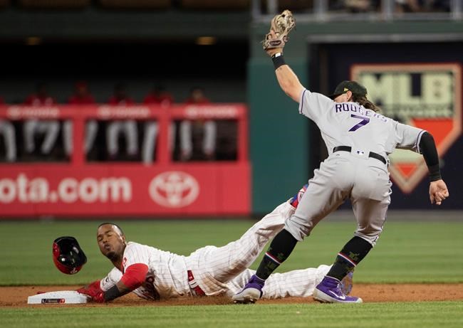 Philadelphia Phillies' Jean Segura, left, gets caught stealing with the tag by Colorado Rockies second baseman Brendan Rodgers, right, during the first inning of a baseball game Friday, May 17, 2019, in Philadelphia. (AP Photo/Chris Szagola)