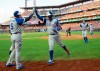 Atlanta Braves' Ronald Acuna Jr., center, gets a high five from Freddie Freeman, left, after hitting a two-run home run, which scored Max Fried, right, during the second inning of a baseball game against the Philadelphia Phillies, Saturday, July 27, 2019, in Philadelphia. (AP Photo/Chris Szagola)