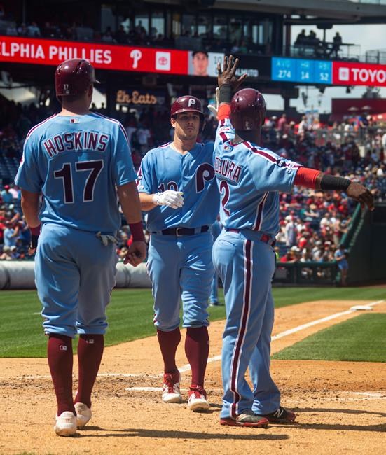 Philadelphia Phillies' J.T. Realmuto, center, celebrates his three-run home run with Jean Segura, right, and Rhys Hoskins, left during the fourth inning of a baseball game against the San Francisco Giants, Thursday, Aug. 1, 2019, in Philadelphia. (AP Photo/Chris Szagola)