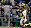 Arizona Diamondbacks' Eduardo Escobar (5) celebrates with David Peralta (6) as he returns to the dugout past Pittsburgh Pirates catcher Elias Diaz, right, after hitting a solo home run off Pirates' Joe Musgrove during the third inning of a baseball game in Pittsburgh, Monday, April 22, 2019. (AP Photo/Gene J. Puskar)
