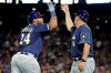 Milwaukee Brewers' Jesus Aguilar, left, rounds third to greetings from third base coach Ed Sedar after hitting a two-run home run off Pittsburgh Pirates relief pitcher Dovydas Neverauskas during the eighth inning of a baseball game in Pittsburgh, Friday, July 5, 2019. (AP Photo/Gene J. Puskar)