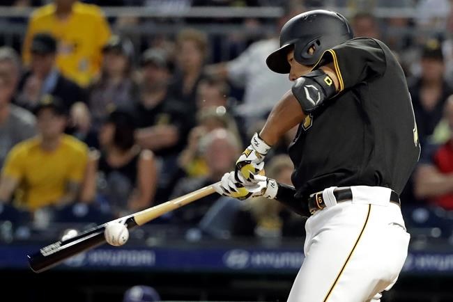 Pittsburgh Pirates' Jung Ho Kang hits a ground ball down the third baseline that San Diego Padres third baseman Manny Machado bobbled and forced an errant throw to first that allowed Kang to advance to second during the seventh inning of a baseball game in Pittsburgh, Friday, June 21, 2019. (AP Photo/Gene J. Puskar)