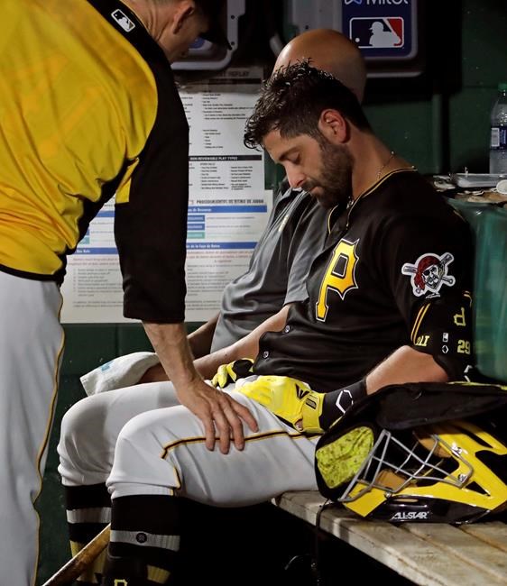 Pittsburgh Pirates catcher Francisco Cervelli is consoled by hitting coach Rick Eckstein, left, after taking himself out of a baseball game against the Los Angeles Dodgers during the fourth inning in Pittsburgh, Saturday, May 25, 2019. Cervelli had been hit in the head by a foul tip in the top of the inning. (AP Photo/Gene J. Puskar)