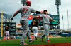 Cincinnati Reds' Scott Schebler (43) is greeted by on deck batter Matt Kemp (27) after he scored on a hit by Yasiel Puig in the third inning of a baseball game, Saturday, April 6, 2019, in Pittsburgh. Pittsburgh Pirates' starting pitcher Trevor Williams (34) and catcher Jacob Stallings (58) walk away. (AP Photo/Keith Srakocic)