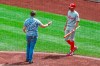Philadelphia Phillies' Brad Miller, right, backs away as a man walks towards him as he comes to bat in the sixth inning of a baseball game against the Pittsburgh Pirates, Sunday, July 21, 2019, in Pittsburgh. The police took the man from the field and play continued. (AP Photo/Keith Srakocic)
