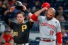 Pittsburgh Pirates' Jake Elmore (68) and Cincinnati Reds' Joey Votto (19) adjust their hats at the same time between pitches after Ellmore walked in the seventh inning of a baseball game, Saturday, Sept. 28, 2019, in Pittsburgh. (AP Photo/Keith Srakocic)
