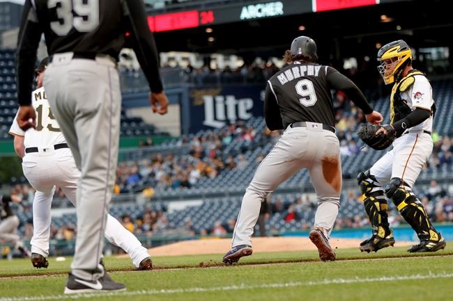 Colorado Rockies' Daniel Murphy (9) heads to home to score after a throw from Pittsburgh Pirates catcher Francisco Cervelli, right, got by third baseman Colin Moran, left, during a rundown in the second inning of a baseball game Tuesday, May 21, 2019, in Pittsburgh. Cervelli was charged with a trowing error. (AP Photo/Keith Srakocic)