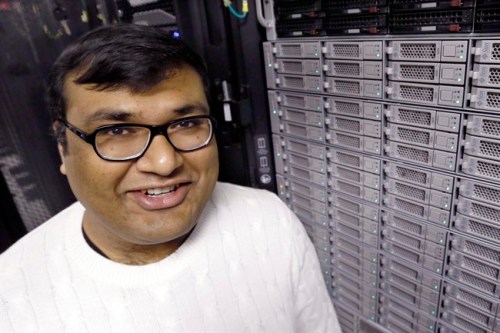 In this Thursday, Nov. 21, 2013 photo, Abhinav Gupta stands near one of the computer clusters used in his research at one of the computer server areas on campus at Carnegie Mellon University in Pittsburgh. The school is letting hundreds of computers run constantly to scan millions of images off the Internet, and have the computers make connections on their own. The plan is to let the system run forever. (AP Photo/Keith Srakocic)