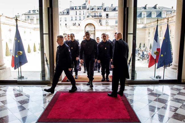 Firefighters and security forces who took part to the fire extinguishing operations at Notre Dame of Paris Cathedral, arrive for a ceremony at the Elysee Palace in Paris, Thursday, April 18, 2019. France paid a daylong tribute Thursday to the Paris firefighters who saved the internationally revered Notre Dame Cathedral from collapse and rescued many of its treasures.(Christophe Petit Tesson, Pool via AP)