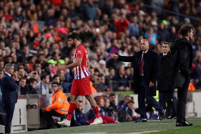 Atletico forward Diego Costa passes his coach Diego Simeone, right, as walks off the pitch after receiving a red card for insulting referee Jesus Gil Manzano during a Spanish La Liga soccer match between FC Barcelona and Atletico Madrid at the Camp Nou stadium in Barcelona, Spain, Saturday April 6, 2019. (AP Photo/Manu Fernandez)