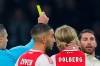 This Wednesday Feb. 13, 2019, image shows referee Damir Skomina, left, showing a yellow card to Real's Sergio Ramos, right, after a foul on Ajax's Kasper Dolberg during the first leg, round of sixteen, Champions League soccer match between Ajax and Real Madrid at the Johan Cruyff ArenA in Amsterdam, Netherlands. UEFA is investigating reported comments by Real Madrid captain Sergio Ramos that he intentionally got a yellow card to provoke a favorable Champions League ban. (AP Photo/Peter Dejong)