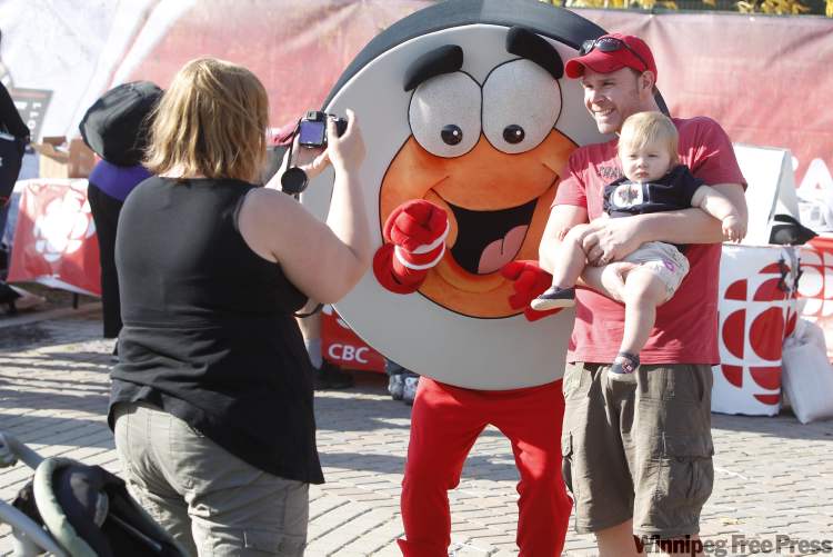 Winnipeg Free Press
Jennifer Pelland takes a picture of her daughter, McKenna, and her husband, Trevor Didham, with Peter Puck at the NHL Faceoff 2011 at The Forks Thursday.