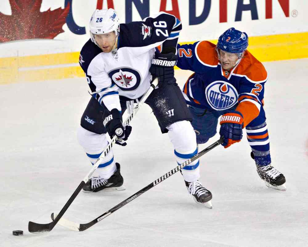 Jason Franson / The Canadian Press
Winnipeg Jets' Blake Wheeler (26) battles for the puck with Edmonton Oilers' Jeff Petry (2) during first-period NHL hockey action in Edmonton Tuesday.