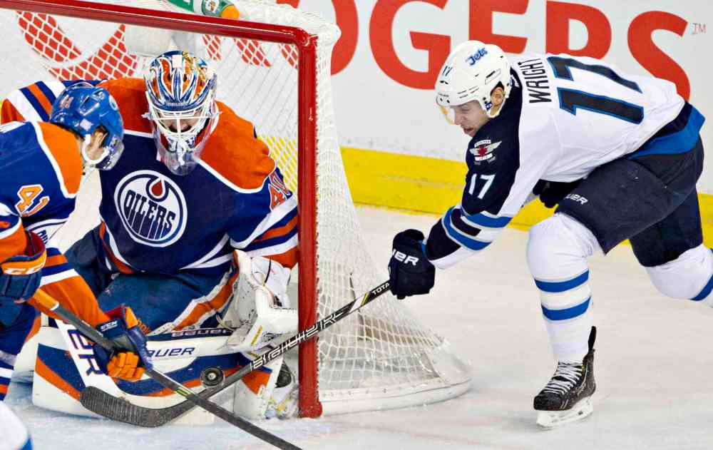 Jason Franson / The Canadian Press
Winnipeg Jets' James Wright (17) is stopped by Edmonton Oilers' Devan Dubnyk (40) as Will Acton (41) chases the rebound during first-period NHL hockey action in Edmonton Tuesday.
