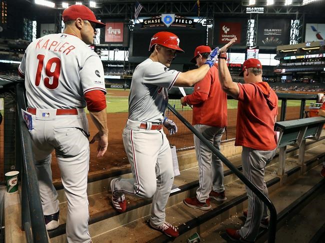 Philadelphia Phillies' Scott Kingery, second from left, celebrates his home run against the Arizona Diamondbacks with manager Gabe Kapler (19), bench coach Rob Thomson, second from right, and hitting coach John Mallee, right, during the second inning of a baseball game Monday, Aug. 5, 2019, in Phoenix. (AP Photo/Ross D. Franklin)