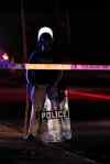 Jeff Roberson / The Associated Press
A police officer in riot gear tries to disperse a crowd in Ferguson, Mo., where police killed an 18-year-old man.