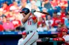 Washington Nationals' Ryan Zimmerman, left, follows through after hitting an RBI-sacrifice fly off Philadelphia Phillies starting pitcher Nick Pivetta during the third inning of a baseball game, Friday, July 12, 2019, in Philadelphia. Phillies catcher Andrew Knapp, right, looks on. (AP Photo/Matt Slocum)