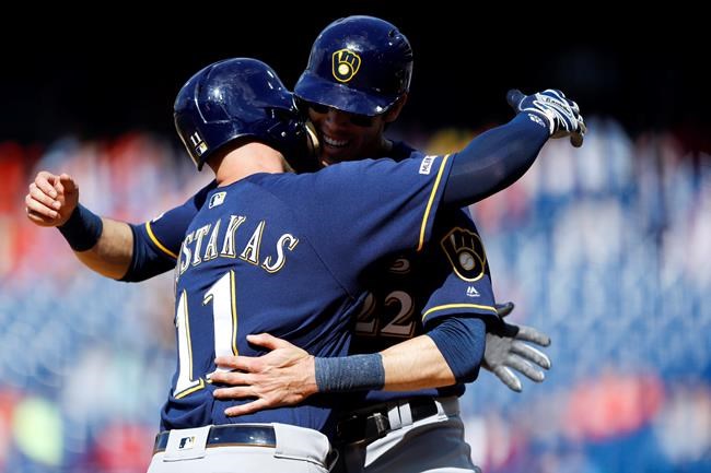 Milwaukee Brewers' Mike Moustakas, left, and Christian Yelich celebrate after Moustakas' two-run home run off Philadelphia Phillies relief pitcher Austin Davis during the ninth inning of a baseball game, Thursday, May 16, 2019, in Philadelphia. Milwaukee won 11-3. (AP Photo/Matt Slocum)