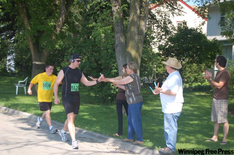 Kathryn McBurney / winnipeg free press
People hand out popsicles on Lyndale Drive to  runners in the Manitoba Marathon today. The runners were all exclaiming, “I can’t believe it! Popsicles — I love you!” to the folks who brought them.