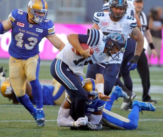 BORIS MINKEVICH / WINNIPEG FREE PRESSRicky Ray gets taken down by Bombers Jamaal Westerman with Trent Corney closing in.