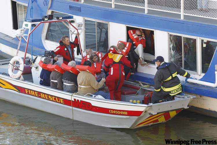 John Woods / Winnipeg Free Press
Passengers are removed from the River Rouge on the Red River at Kingston Row Friday.