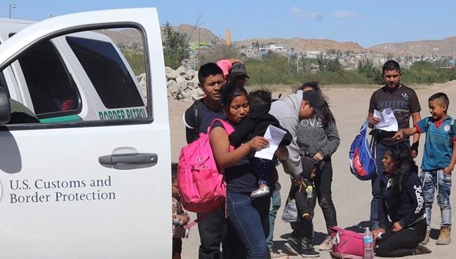 In this April 2019, frame from video, migrants turn themselves in to border agents in El Paso, Texas, after crossing the US - Mexico border. El Paso has swiftly become one of the busiest corridors for illegal border crossings in the U.S. after years as one of the sleepiest. (AP Photo/Cedar Attanasio)
