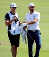 FILE - In this Jan. 4, 2017, file photo, Dustin Johnson, right, exchanges clubs with his caddy, brother Austin Johnson, on the 18th green during the pro-am prior to the Tournament of Champions golf event, at Kapalua Plantation Course in Kapalua, Hawaii. Austin Johnson jokes they are more feel players than 