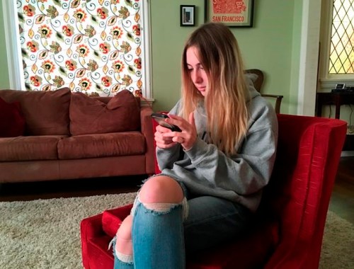 In this Nov. 1, 2018 photo, Laurel Foster holds her phone in San Francisco. Foster is among teens involved in Stanford University research testing whether smartphones can be used to help detect depression and potential self-harm. (AP Photo/Haven Daley)