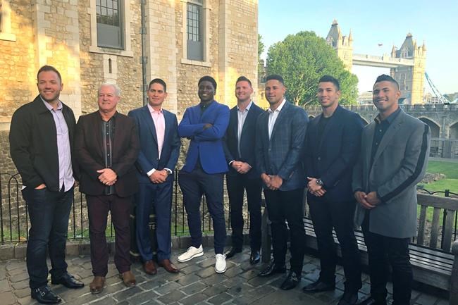 From left, New York Yankees catcher Austin Romine, batting practice pitcher Danilo Valiente, coach Carlos Mendoza, shortstop Didi Gregorius, pitcher Zack Britton, catcher Gary Sanchez, pitcher Luis Cessna and shortstop Gleyber Torres pose outside the Tower of London, Friday, June 28, 2019. At rear right is the Tower Bridge. The Yankees and Boston Red Sox are playing two baseball games in London this weekend. (AP Photo/Ron Blum)
