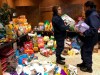 In this Thursday, Jan. 17, 2019 photo, members of the U.S. Coast Guard browse through bags of donated pet food at a pop-up pantry created by local Coast Guard-related advocacy groups to help the hundreds of civilian and non-civilian Coast Guard employees in New London, Conn., impacted by the partial federal shutdown. The outpouring from the community has been so great, the pantry has separate sections, including pet supplies, personal care and gluten-free food items. (AP Photo/Susan Haigh)