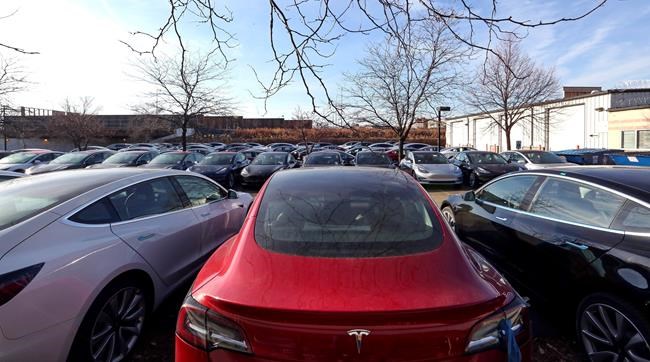 This Dec. 18, 2018, photo shows a lot full of Tesla vehicles in Chicago. Tesla made about 9,300 more vehicles than it delivered in 2018, raising concerns among industry analysts that inventory is growing as demand for the company's electric cars may be starting to wane. (AP Photo/Teresa Crawford)