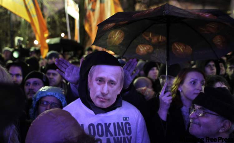 Sergey Ponomarev / the associated press
A man wearing a Vladimir Putin mask attends a rally in Moscow on Monday.